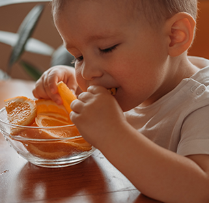criança comendo laranja